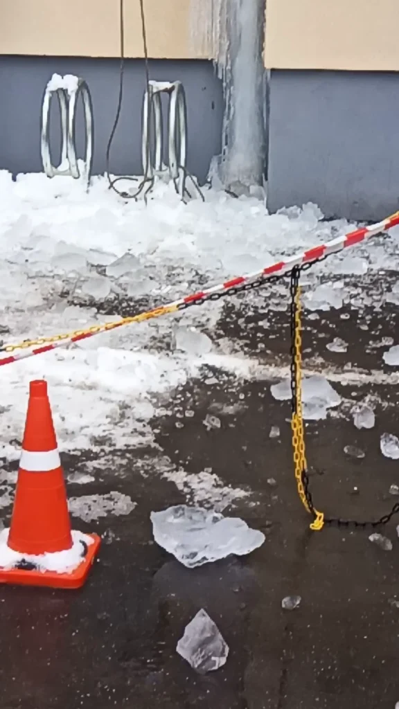 лёд с водосточной трубы и ограждение зоны работ